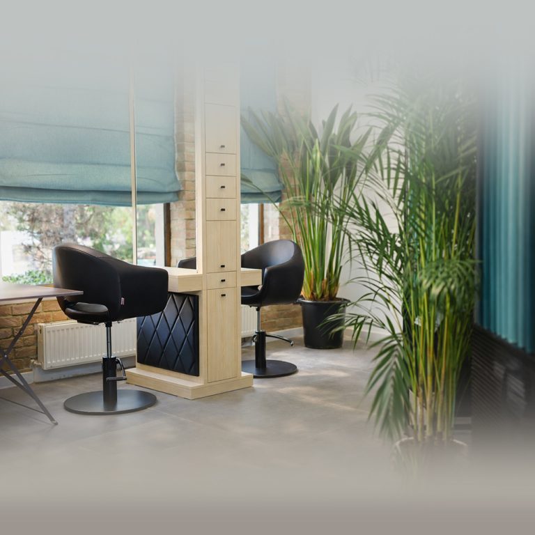 posturi coafor cu oglindă, scaune negre și plante decorative într-un salon modern amenajat