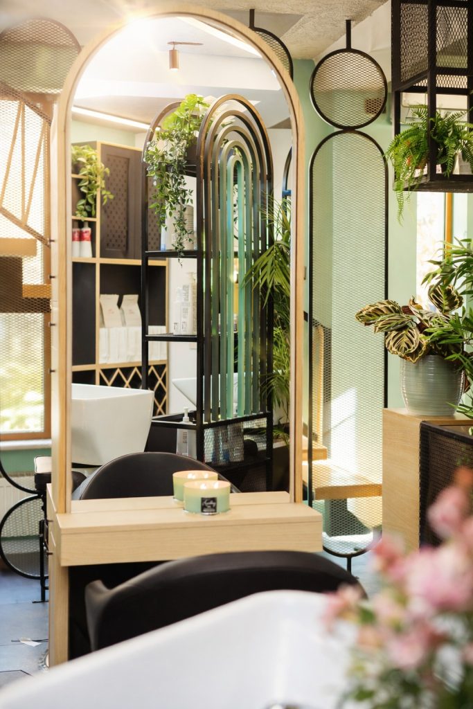 zona de coafura salon Lumi Hair Style cu oglinda mare plante si elemente metalice intr-un design modern si cald